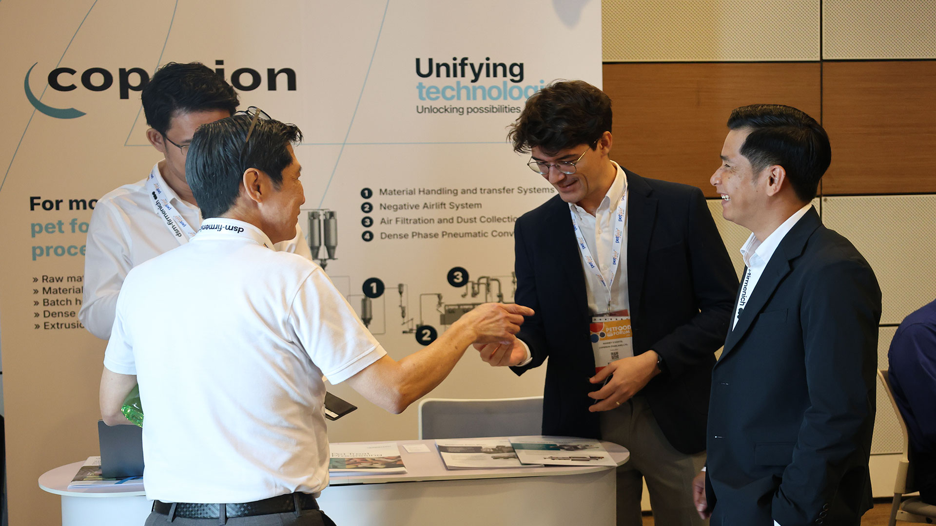 Coperion tabletop display with men talking at Petfood Forum Asia
