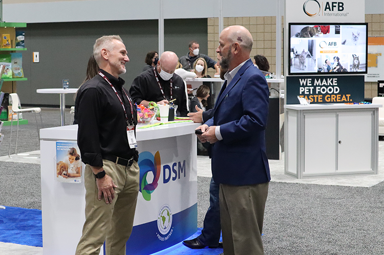Two business men engaged in booth at Petfood Forum