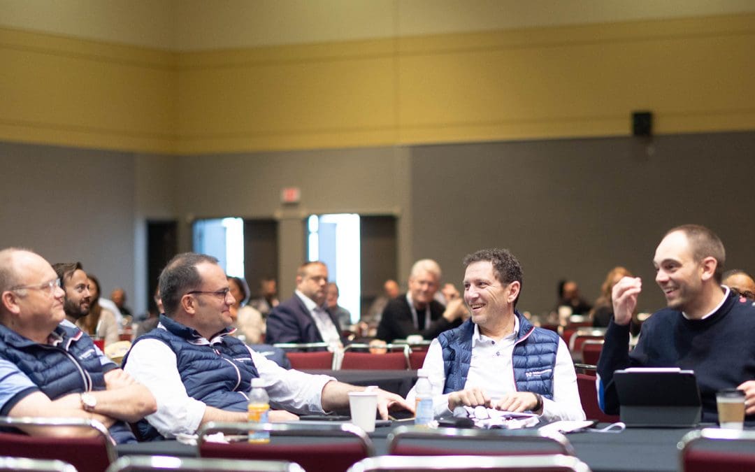 Four white males talk around a table at Petfood Forum