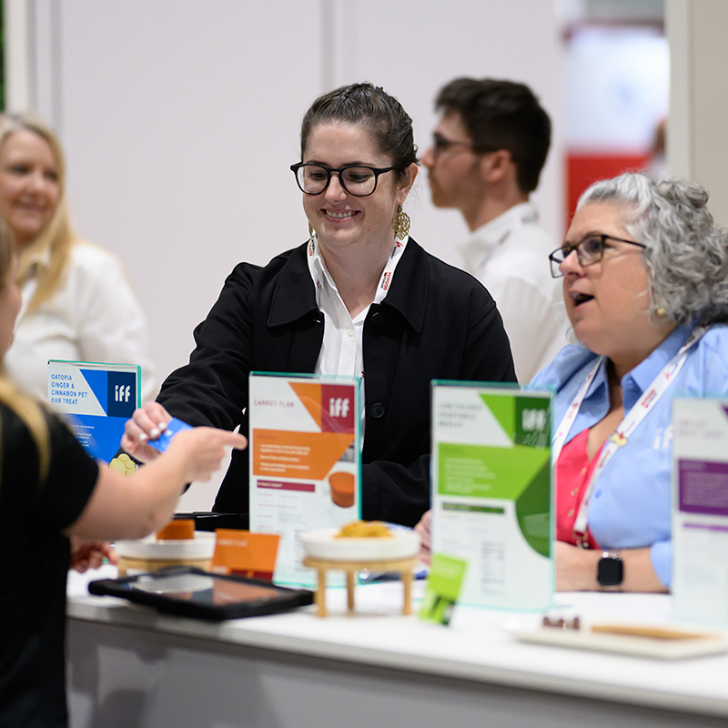 Female attendees exchanging business cards at Petfood Forum