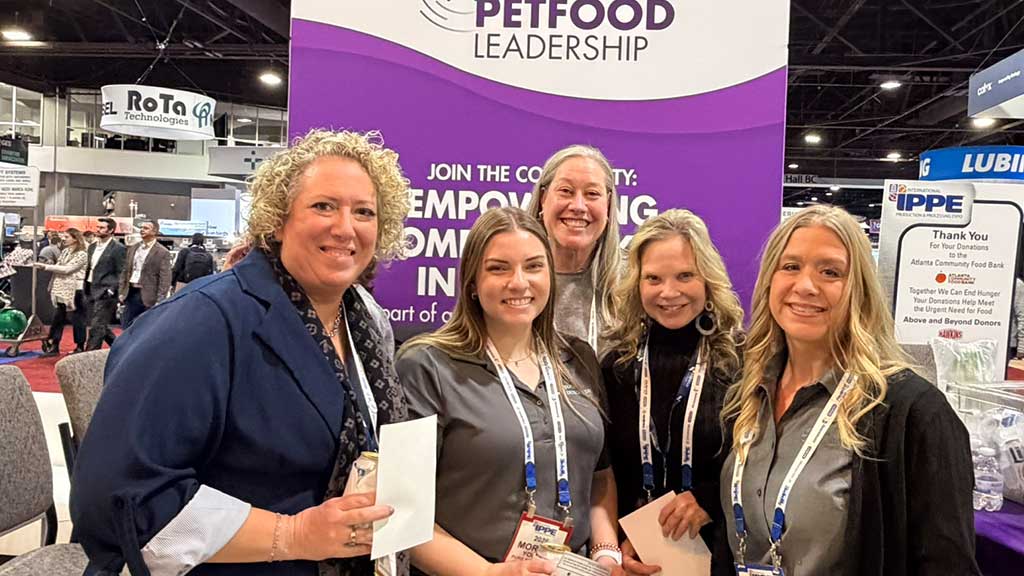 5 women pose in front of Women in Petfood Leadership sign at IPPE