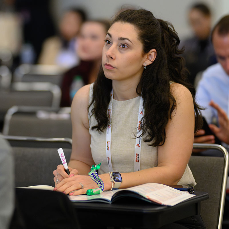Female attendee in session room at Petfood Forum taking notes