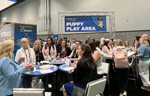Group of women gathered in the Puppy Play Area at Global Pet Expo